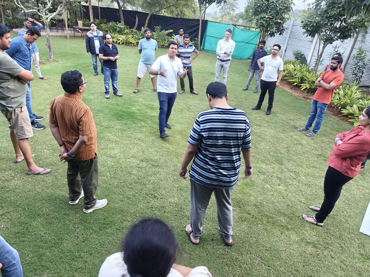 A facilitator leading a circle discussion outdoors